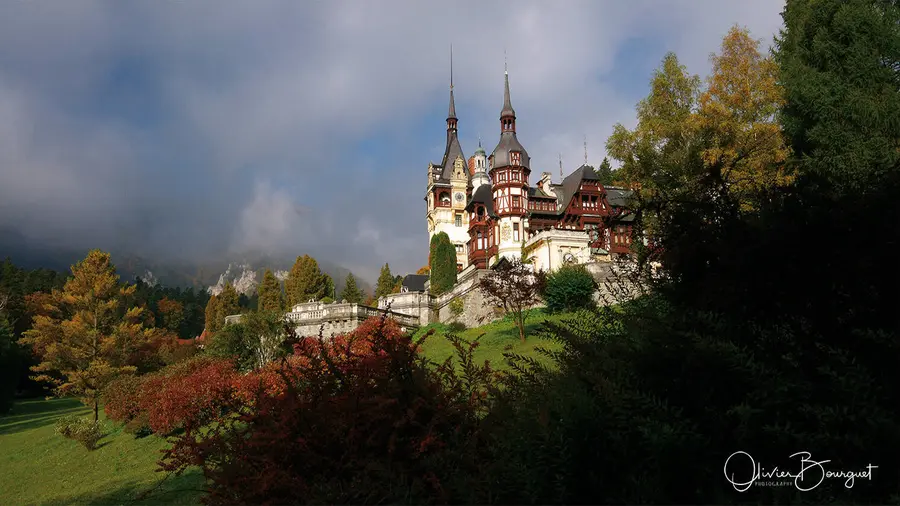 Un château aux tourelles pointues dans les arbres d’automne, Roumanie