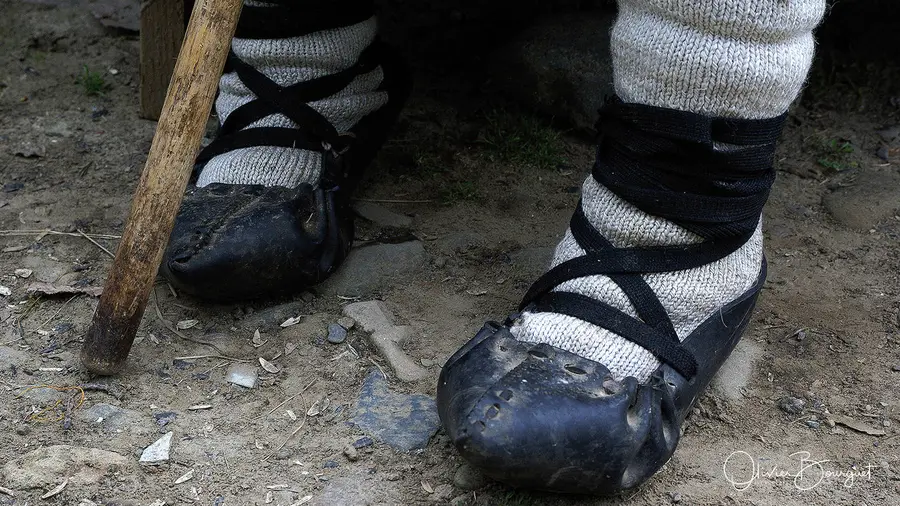 Pieds chaussés de sandales traditionnelles lacées, dans le Maramurès